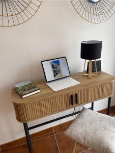 a desk with a laptop and a lamp on it at The Doll’s House in Tavira
