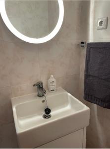 a bathroom sink with a round mirror above it at The Doll’s House in Tavira
