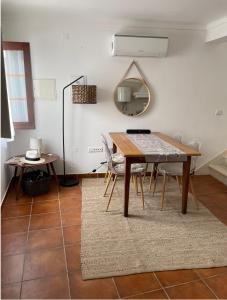 a dining room with a table and chairs and a mirror at The Doll’s House in Tavira