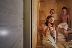 un chico y una chica sentados en una sauna en Horská chata 3 SKALKY so saunou a jacuzzi kaďou, en Smižany