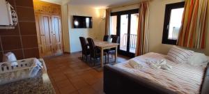 a bedroom with a bed and a table with chairs at Apartamentos Boabdil in Sierra Nevada