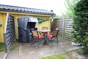 eine Terrasse mit einem Tisch und Stühlen im Hinterhof in der Unterkunft Windjammer in Ostseebad Koserow