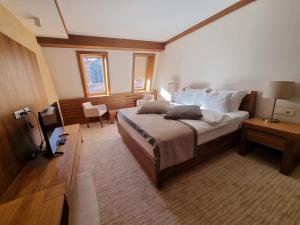 ein Schlafzimmer mit einem großen Bett und einem Tisch und Stühlen in der Unterkunft RT APARTMANI VUČKO JAHORINA in Jahorina