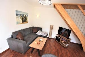 Una sala de estar con un sofá y un televisor. en Windjammer, en Ostseebad Koserow