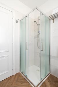 baño con cabina de ducha de cristal y paredes blancas en Residence Atlantico, en Lido di Jesolo