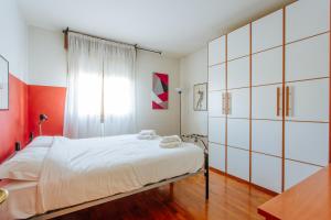 um quarto com uma cama branca e uma janela em Yourbanflat Sweet Home em Pádua