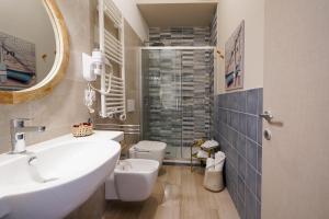 a bathroom with a sink and a toilet and a mirror at Mediterranea Apartment- CENTRAL STATION - FREE WIFI&NETFLIX in Bari