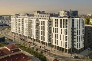 a large white building in a city with a street at Primo V by LookAp in Łódź