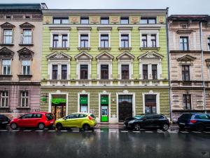 a yellow building with cars parked in front of it at Radziwillowska Old Town Deluxe Apartment WAWELOFTS in Krakow