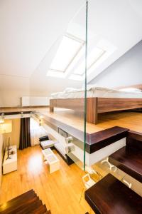 a loft bedroom with a bed and a glass wall at Radziwillowska Old Town Deluxe Apartment WAWELOFTS in Krakow