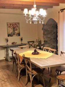 une salle à manger avec une table, des chaises et un lustre dans l'établissement Alba D'Esteve. Casa Rural, à Espot