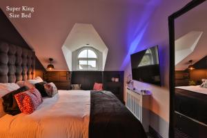 1 dormitorio con 1 cama grande y techo púrpura en The Rockefeller Apartments, en Bowness-on-Windermere