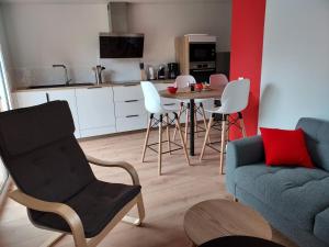 a living room with a couch and a table and chairs at La Clé du Chesnot in Saint-Quentin-sur-le-Homme