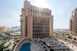 Blick auf ein großes Gebäude mit Pool in der Unterkunft Al Gassar Resort in Doha