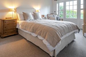 1 dormitorio con 1 cama grande, vestidor y ventana en Lily Cottage by Big Skies Cottages, en Little Walsingham