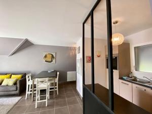 cocina y sala de estar con mesa y sofá en Superbe appartement terrasse, proche de la plage, en Bénodet