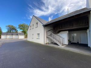 a large white building with a staircase next to it at Superbe appartement terrasse, proche de la plage in Bénodet