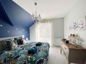 una camera con un grande letto con una parete blu di Superbe appartement terrasse, proche de la plage a Bénodet