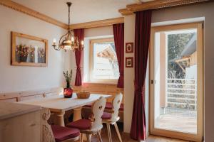 comedor con mesa, sillas y ventana en Residence Nagler - BelaVal Apartments, en Badia