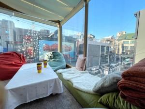 ソウルにあるココア ゲストハウスのテーブルと大きな窓が備わる客室です。