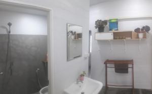 a white bathroom with a sink and a shower at Hunny Home in Ko Yao Noi
