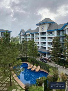 un hotel con piscina di fronte a un edificio di CozyVilla at Pine Suites Tagaytay 2BR or Studio with FREE PARKING 2br in Basement parking and studio in offsite parking a Tagaytay