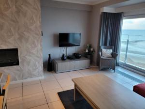 a living room with a flat screen tv and a couch at Beach Palace in Middelkerke