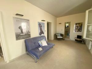 a living room with a blue couch and a chair at KARMI Apartments Stenies Andros in Andros