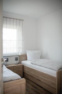 two twin beds in a bedroom with a window at Havelstern Ketzin, Ferienhaus Zander in Ketzin