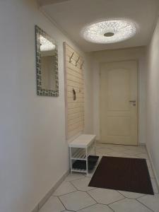 een hal met een deur en een bank en een spiegel bij Ferienwohnung in der Siedlung in Klinga