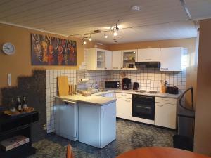 a kitchen with white appliances and white cabinets at Ferienwohnung in der Siedlung in Klinga