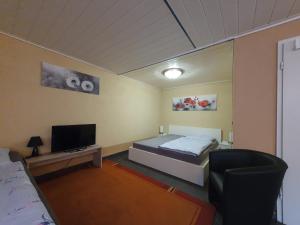 Cette petite chambre comprend un lit et une télévision. dans l'établissement Ferienwohnung in der Siedlung, à Klinga