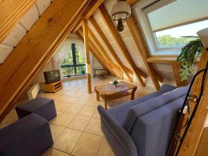 ein Wohnzimmer mit einem blauen Sofa und einem TV in der Unterkunft Glattbacher Hof Ferienwohnung 10 in Glattbach