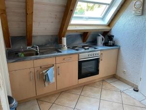 eine Küche mit einer Spüle, einem Herd und einem Fenster in der Unterkunft Glattbacher Hof Ferienwohnung 10 in Glattbach
