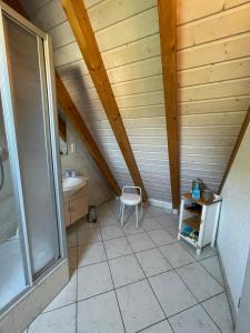 ein Bad im Dachgeschoss mit einem Waschbecken und einem Stuhl in der Unterkunft Glattbacher Hof Ferienwohnung 10 in Glattbach