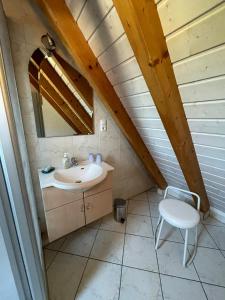 ein Badezimmer mit einem Waschbecken und einem Stuhl im Dachgeschoss in der Unterkunft Glattbacher Hof Ferienwohnung 10 in Glattbach