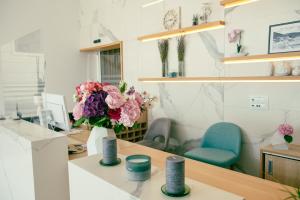 una oficina con un jarrón de flores en un escritorio en Hotel Nova, en Neum