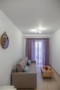 AGIOS PETROS APARTMENTS في Ágios Pétros: غرفة معيشة مع أريكة وطاولة