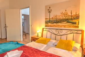 1 dormitorio con 1 cama con una pintura en la pared en Central Apartments, en Budapest