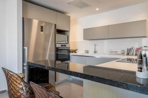 a kitchen with a black counter and a refrigerator at Front of the Old City in Jerusalem - Luxurious Residence in Jerusalem