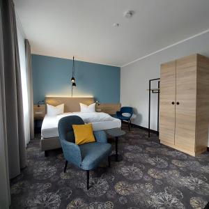 een hotelkamer met een bed en een stoel bij Hotel Purucker in Kulmbach