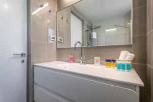W łazience znajduje się umywalka i lustro. w obiekcie Front of the Old City in Jerusalem - Luxurious Residence w Jerozolimie