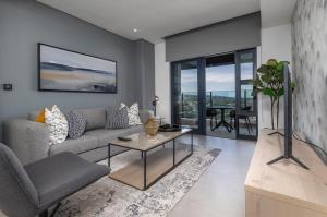 a living room with a couch and a table at 2202 Oceans Apartment - by Stay in Umhlanga in Durban