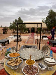 een tafel met meerdere borden eten bovenop bij camp erg chebbi luxury in Merzouga