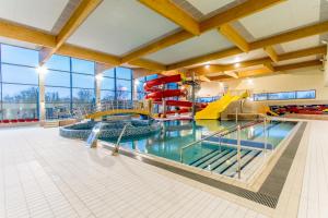 a large indoor swimming pool with a water slide at BOSiR Białogard in Białogard