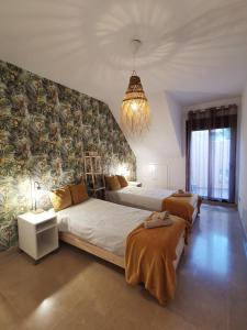a large bedroom with two beds and a chandelier at Penthouse 6-8 personnes in Manilva