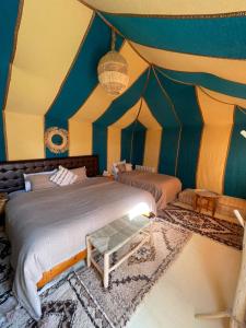 een slaapkamer met een bed in een tent bij camp erg chebbi luxury in Merzouga