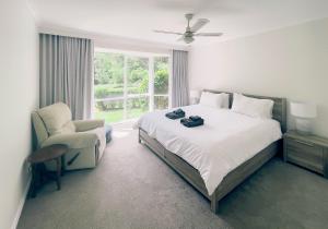 sypialnia z łóżkiem, krzesłem i oknem w obiekcie Sanctuary Park Cottages w mieście Healesville