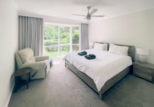 una camera da letto con un letto, una sedia e una finestra di Sanctuary Park Cottages a Healesville Altre 43 foto