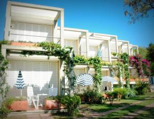 un grande edificio bianco con molte piante di Hotel Viticcio a Portoferraio